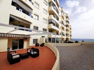 a large building with chairs and tables in front of it at Banana Beach in Marbella