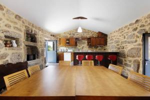ein Esszimmer und eine Küche mit einem Holztisch und Stühlen in der Unterkunft Quinta de Ramil in Rossas