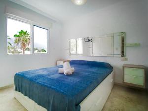 a bedroom with a large blue bed with a mirror at Banana Beach in Marbella
