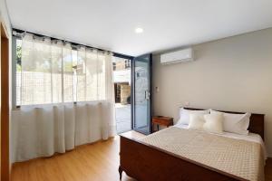 ein Schlafzimmer mit einem Bett und einem großen Fenster in der Unterkunft Quinta de Ramil in Rossas + 34 Fotos