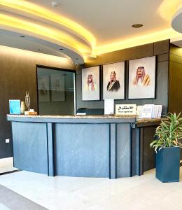 a lobby with a blue counter with pictures on the wall at ELGOUN Serviced apartments in Riyadh