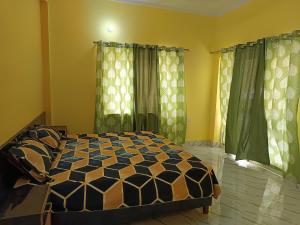 a bedroom with a bed and green curtains at Welcome Home Stay & Hotel Tapovan Rishikesh in Rishīkesh