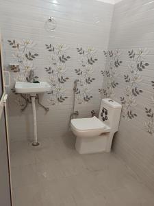 a bathroom with a toilet and a sink at Welcome Home Stay & Hotel Tapovan Rishikesh in Rishīkesh