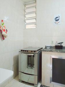 a kitchen with a stove and a counter with a stool at Casa aconchegante no Centro da Cidade - Cantinho da Bia MP in Miguel Pereira +35 photos