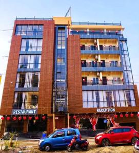 KalyaniN B Sonar Bangla Hotel的两辆车停在大楼前的建筑物