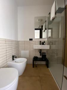 a white bathroom with a sink and a toilet at Casa eFFe in Tortolì