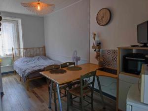 a bedroom with a table and a bed and a table and chairs at Le nid douillet Champêtre Linge fourni in La Bourboule