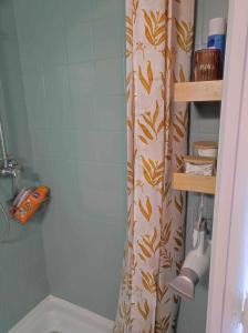 a bathroom with a shower curtain and a tub at Le nid douillet Champêtre Linge fourni in La Bourboule +14 photos
