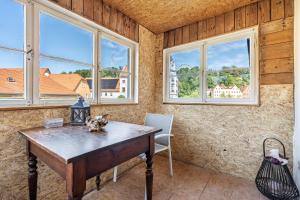 a room with a wooden table and windows at Ferienhaus Unterm Schloss in Bautzen