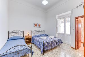 a bedroom with two beds and a window at Appartamento Lido Marini in Lido Marini