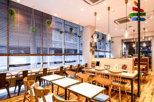a restaurant with tables and chairs and windows at Comfort Hotel Tokyo Kanda in Tokyo