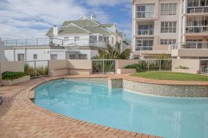 a swimming pool in front of a apartment building at Modern Seaview Apartment in Summerstrand
