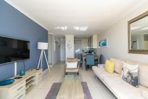 a living room with a couch and a television at Modern Seaview Apartment in Summerstrand