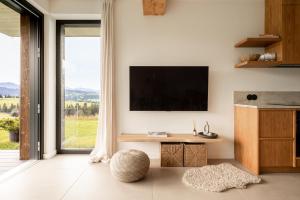 a living room with a flat screen tv on a wall at NOOK Cabins - Mountain View in Zakopane