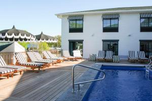a deck with lounge chairs and a swimming pool at The Inn Hotel Lake Okoboji, an Ascend Collection Hotel in Arnolds Park