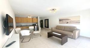 a living room with a couch and a table at Fuerteventura Atlantic Gardens Corralejo in Corralejo