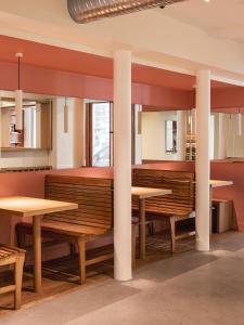 a dining room with wooden tables and benches at New Hotel Opéra in Paris