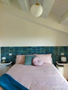 1 dormitorio con 1 cama con almohadas rosas y verdes en Oltremare Numana, en Numana