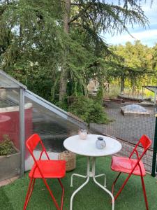 two red chairs and a white table on a patio at COUETTE et CAFÉ L'AGENCE in Boutigny-sur-Essonnes