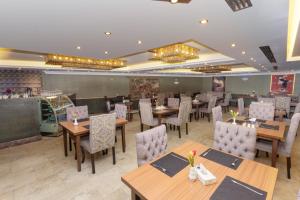a dining room with wooden tables and chairs at Strand Hotel Jordan in Amman