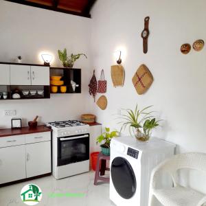 a kitchen with a stove and a washing machine at Ceylon Heaven in Wadduwa +15 photos