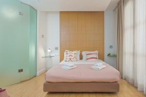 Un dormitorio con una cama grande con almohadas rosas y blancas. en Chic Hotel, en Atenas