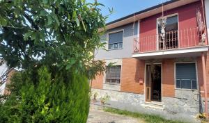 an apartment building with a tree in front of it at Casa dei Libri nel Monferrato in Pontestura