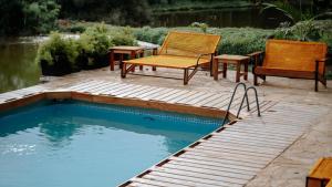 two chairs and a table next to a swimming pool at ViaVia Entebbe in Entebbe