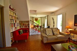 a living room with a couch and a red chair at Maison Capanelli in Casa delle Torre