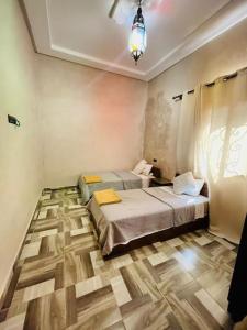 a bedroom with two beds and a chandelier at Villa des tortues 3 Marrakech piscine chaufée privative sans vis à vis in Marrakesh +28 photos