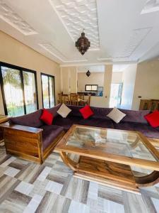 a living room with a couch and a glass table at Villa des tortues 3 Marrakech piscine chaufée privative sans vis à vis in Marrakesh
