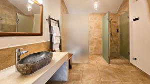 a bathroom with a stone sink and a shower at Zahara Sol Villas y Apartamentos by QHotels in Zahara de los Atunes