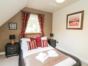 a bedroom with a bed with two night stands at Taighean Anndra in Killin