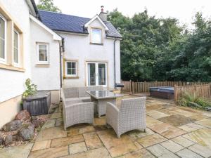 a patio with a table and chairs in front of a house at Taighean Anndra in Killin