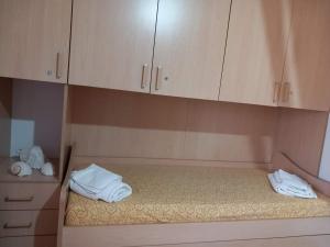 a room with a bed with white towels and cabinets at La Casa di Anna in Lampedusa +23 photos