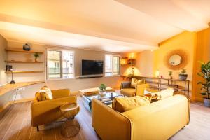 a living room with yellow furniture and a flat screen tv at Loft COSY et luxueux, HYPER-CENTRE in Aix-en-Provence +16 photos
