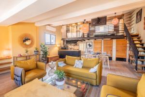 a living room with yellow furniture and a staircase at Loft COSY et luxueux, HYPER-CENTRE in Aix-en-Provence