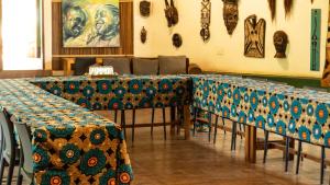 a row of tables in a room with blue and green at ViaVia Entebbe in Entebbe
