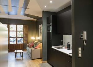 a kitchen with black walls and a couch and a sink at Apartamentos Ele San Justo Plaza in Salamanca