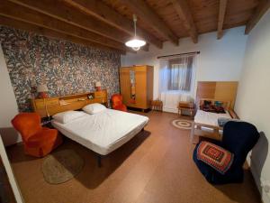 a bedroom with two beds and chairs in a room at La Cadette des 2 Frangines in Mazeyrat-Aurouze