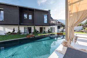 a house with a swimming pool in front of a house at Chalet Merangardenvilla in Merano