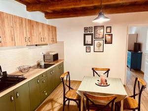 a kitchen with a table and chairs in a kitchen at Palócföldi Menedék in Kazár