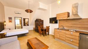 a room with a bed and a kitchen with a table at Zahara Sol Villas y Apartamentos by QHotels in Zahara de los Atunes