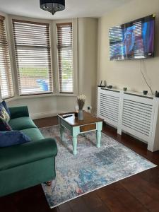 a living room with a green couch and a coffee table at Railwayview Lodge in Bangor