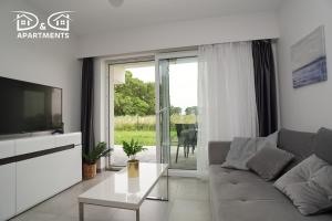 a living room with a couch and a tv at Apartamenty Morze u Sary in Dziwnówek