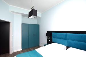 a bedroom with a blue bed and a blue cabinet at Stay with Legends in Hamburg