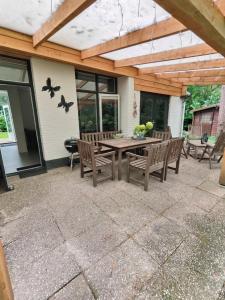 a patio with a wooden table and chairs at Knabbel en Babbel in Lochem