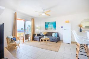 a living room with a couch and a kitchen at Blue Garden - cozy apartment with Atlantic views in Puerto de Santiago