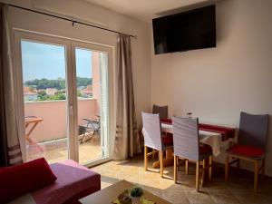 a living room with a table and chairs and a balcony at Apartments Maričić Rab Island in Rab