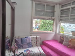 a room with a couch and a window with pink sheets at QUARTO PRIVADO COM INTERNETE PRÓXIMO A UFGS in Porto Alegre +30 photos